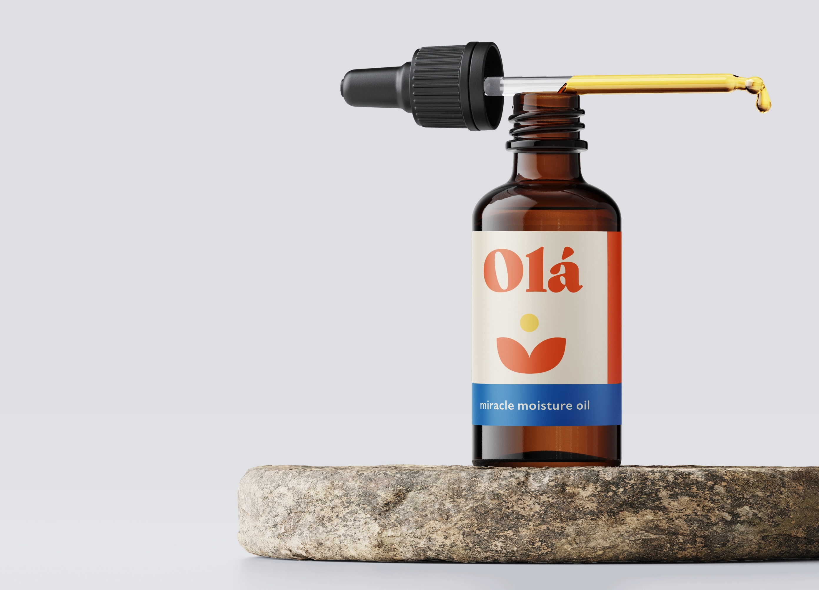 a dropper bottle of the colourful Ola Miracle Moisture Oil packaging sitting on a round stone